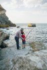 Nonno e nipote pescano insieme in mare — Foto stock
