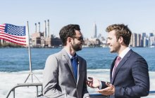 Zwei Geschäftsleute im Gespräch auf der Fähre auf dem East River, New York City, USA — Stockfoto