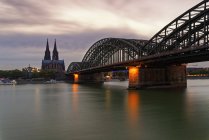 Germany, Cologne, view to Cologne Cathedral with Hohenzollern Bridge in the foreground at evening twilight — Stock Photo