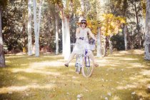 Женщина балансирует на велосипеде в осеннем парке — стоковое фото