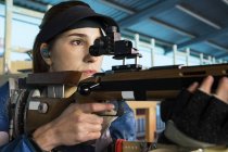 Женщина со спортивной винтовкой в тире — стоковое фото