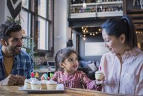 Familie am Küchentisch mit Geburtstagstorten — Stockfoto