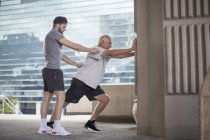 Fitnesstrainerin führt Senior bei Dehnübungen — Stockfoto