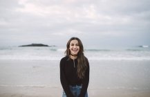 Портрет смішної молодої жінки стоїть на пляжі — стокове фото