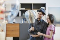 Portrait of couple looking at table lamp in furniture store — Stock Photo