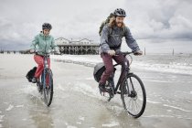 Щаслива пара їде на велосипеді на пляжі — стокове фото