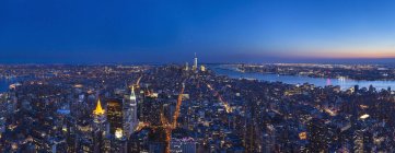 EUA, Nova York, Manhattan, panorama do distrito financeiro iluminado ao entardecer, vista aérea — Fotografia de Stock