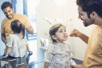 Father brushing his toddler daughter teeth in bathroom — Stock Photo