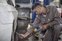 Automechaniker in einer Werkstatt beim Reifentanken — Stockfoto