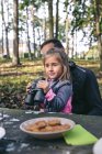 Bambina con binocolo rilassante con il padre in una foresta — Foto stock