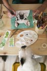 Mano de mujer pintando una acuarela de bulldog francés - foto de stock