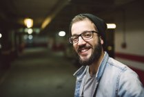Porträt eines lächelnden lässigen Mannes in einer Garage — Stockfoto