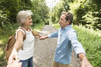 Aktives Senioren-Paar hält Händchen mit Zuschauer im Park — Stockfoto