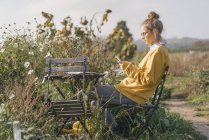 Молодая женщина отдыхает в коттеджном саду — стоковое фото