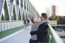 Senior couple embracing on a bridge — Stock Photo