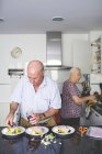 Senior couple preparing food in the kitchen — Stock Photo