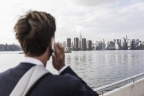 Homme au téléphone avec skyline de Manhattan sur fond, New York, États-Unis — Photo de stock