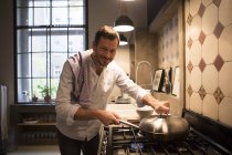 Ritratto di uomo sorridente che cucina a casa — Foto stock