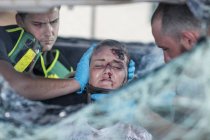 Los paramédicos ayudan a la víctima de accidente de coche después del accidente - foto de stock