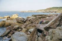 Großvater und Enkel angeln gemeinsam auf Felsen auf See — Stockfoto
