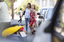 Mãe e filha caminhando juntas com sacos de compras na movimentada rua da cidade — Fotografia de Stock