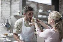 Couple tasting their own cooked food in cooking class — Stock Photo