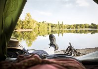 Gambe di una donna sdraiata in tenda in un lago — Foto stock