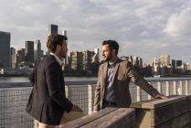 Deux hommes d'affaires discutant à East River, New York, USA — Photo de stock