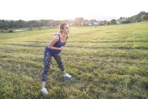 Young pregnant sporty woman making exercises outdoors — Stock Photo