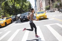 USA, New York City, woman running on urban street — Stock Photo