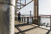 США, Нью-Йорк, людина, що біжить на Іст-Рівер під Бруклінського мосту — стокове фото