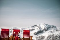 Austria, Altenmarkt-Zauchensee, couple sitting at hooded beach chair in the mountains — Stock Photo