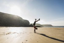 Uomo in piedi sulle mani sulla spiaggia, Francia, penisola crozon — Foto stock