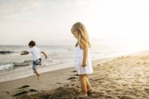 Bonito caucasiano pouco irmão e irmã se divertindo na praia de areia — Fotografia de Stock