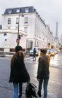 France, Paris, deux jeunes femmes marchant dans la rue avec la Tour Eiffel en arrière-plan — Photo de stock