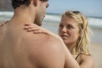 Tenera giovane coppia in piedi sulla spiaggia — Foto stock