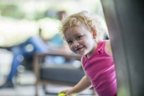Baby girl smiling from corner at home — Stock Photo