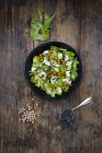 Чаша салата из листьев с жареным горохом, авокадо, фета и черным кунжутом — стоковое фото