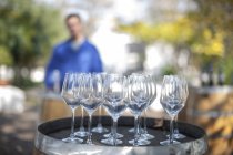 Empty wine glasses on barrel with estate worker on background — Stock Photo