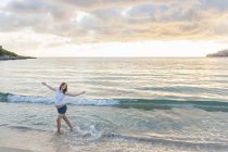 Счастливая беременная женщина танцует на пляже — стоковое фото