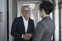 Geschäftsmann und Geschäftsfrau geben sich die Hand — Stockfoto