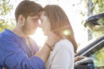 Coppia abbracciare e baciare durante il viaggio in auto vicino — Foto stock