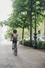 Joven montando bicicleta en el pavimento de la ciudad - foto de stock