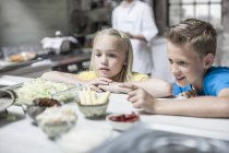 Inquisitive siblings shows interest  in cooking class — Stock Photo