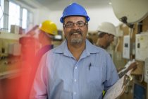 Instructor electricista sonriente con estudiantes de fondo - foto de stock