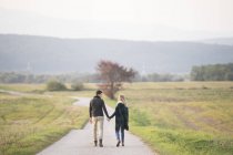Jovem casal caminhando na paisagem rural — Fotografia de Stock