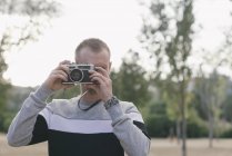 Мужчина фотографирует на винтажную камеру — стоковое фото