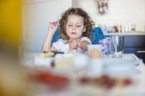 Mädchen sitzt am Frühstückstisch, Blick über die Oberfläche — Stockfoto