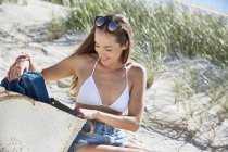 Giovane donna con borsa da spiaggia sulla spiaggia — Foto stock