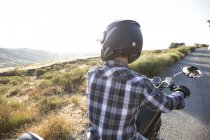Человек на мотоцикле по проселочной дороге — стоковое фото